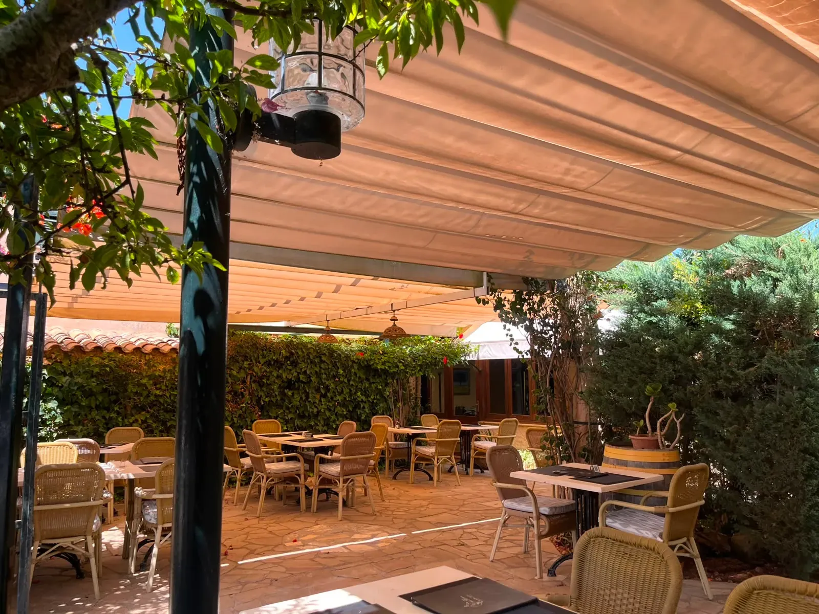 Covered terrace with an awning and shaded tables